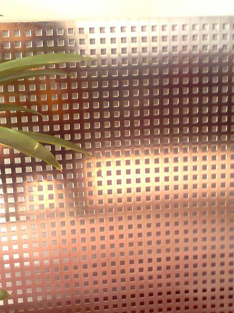 A perforated copper sheet with straight square holes