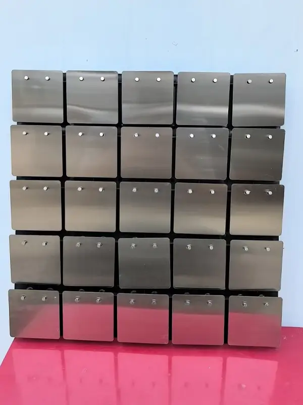 Square metallic plates are mounted using a back plate, presenting a neat and orderly grid structure.