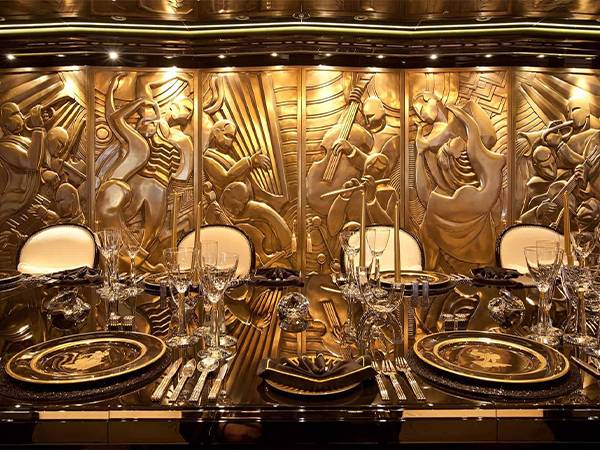 Bronze relief sculpture acts as restaurant partition.