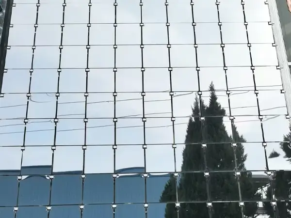 Mirror wall with cable hanging mounting, reflecting surroundings and a photographer