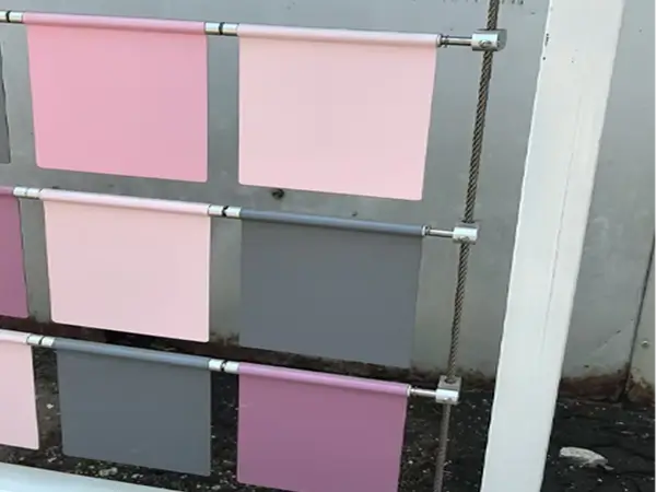 A part of the device with pink, light pink and gray square plates, via cable hanging mounting