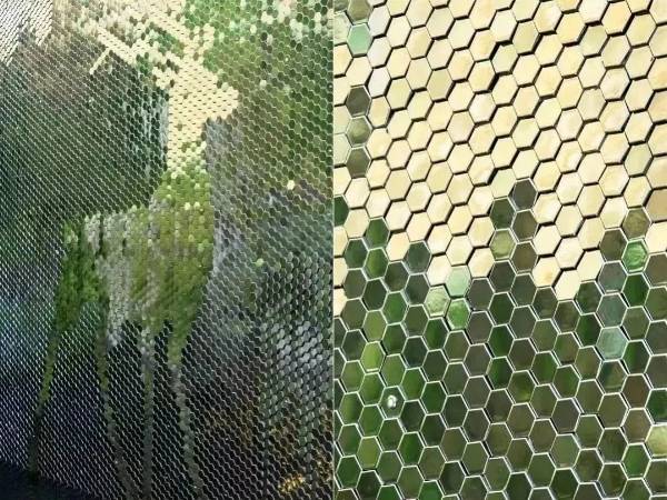 Hexagonal metal perforated kinetic panels, reflecting the green of plants