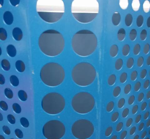 Light blue windbreak panel with rows of round holes.