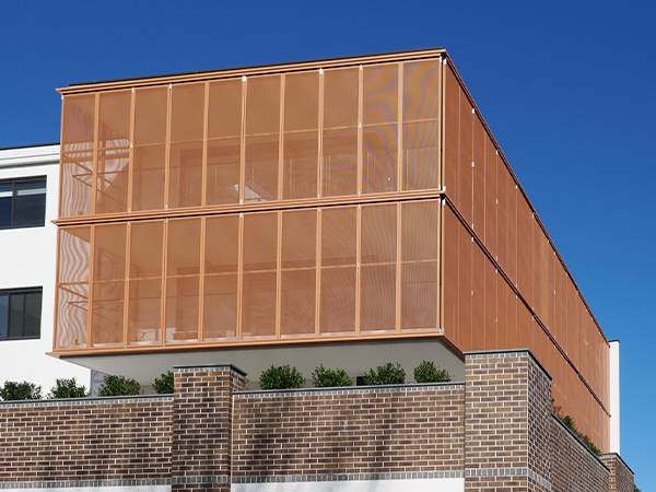 La fachada de un edificio está hecha de láminas de latón perforadas
