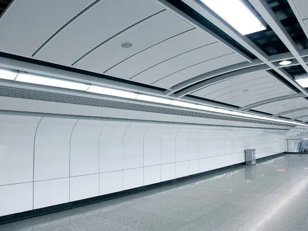 Perforated metal acoustic panels installed on the station ceiling