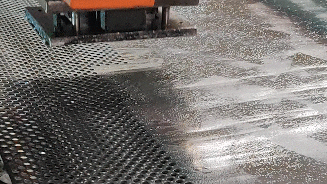 A machine is CNC punching a perforated sheet.