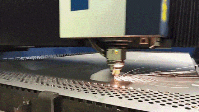 A machine is laser cutting a perforated sheet.
