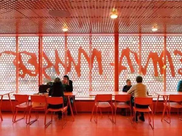 Orange-red round perforated sheets used to separate spaces inside the dining room