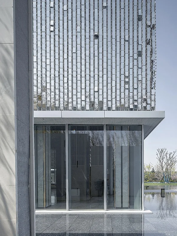 The silver perforated kinetic facade resembles a mirror.